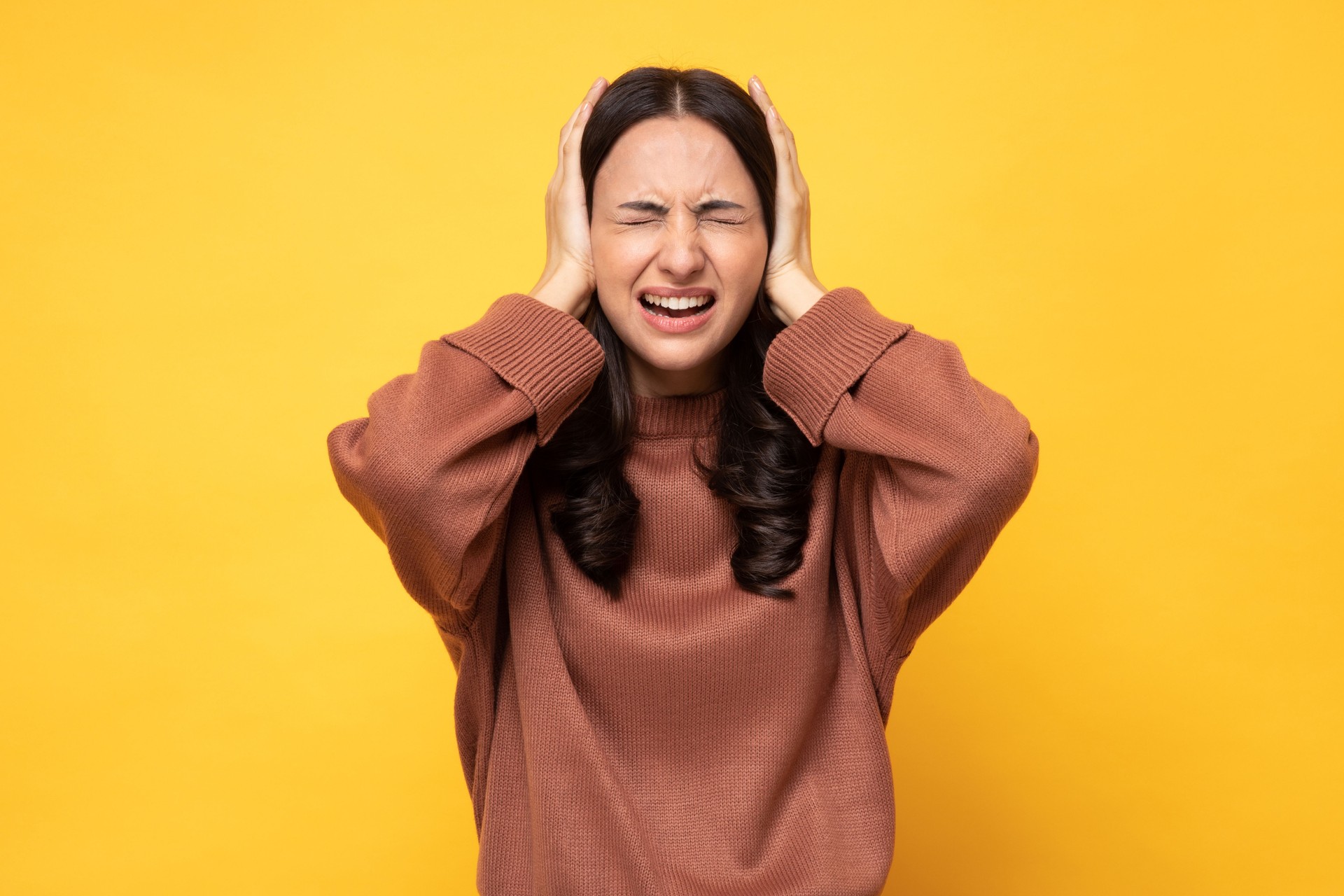 Photo of young women in winter wear standing on yellow background stock photo